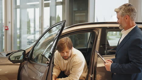 car salesman discussing with customer in dealership