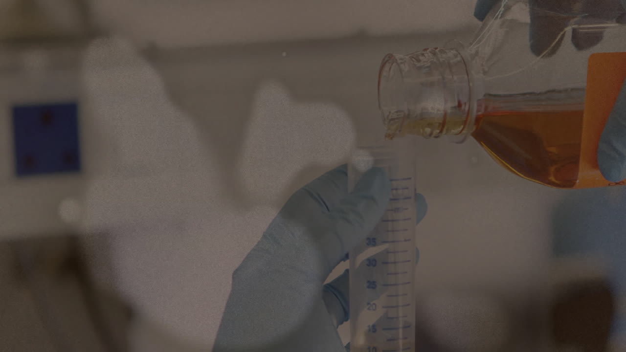 Pouring liquid into graduated cylinder, gloved hands working in laboratory setting