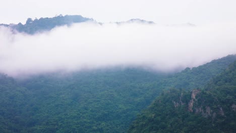 Timelapse-in-Khao-Yai-province,-Thailand-with-low-lying-dense-fog-over-the-mountainous-terrain-of-jungle-and-trees-during-the-early-morning