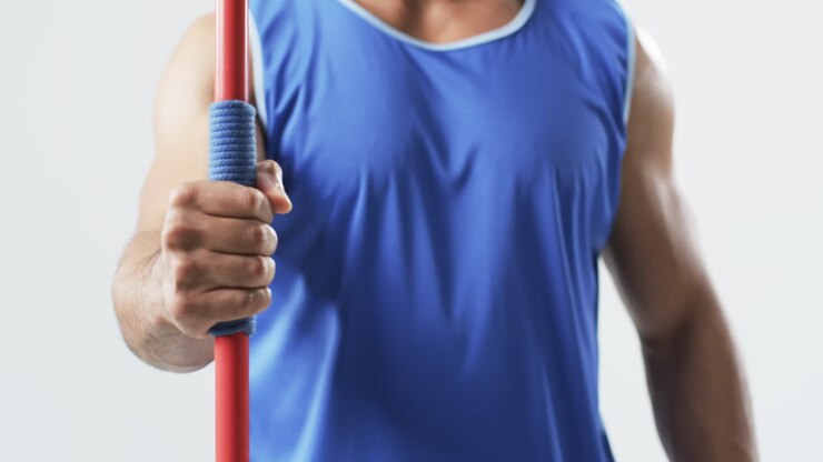 Young biracial athlete man holding a javelin on a white background