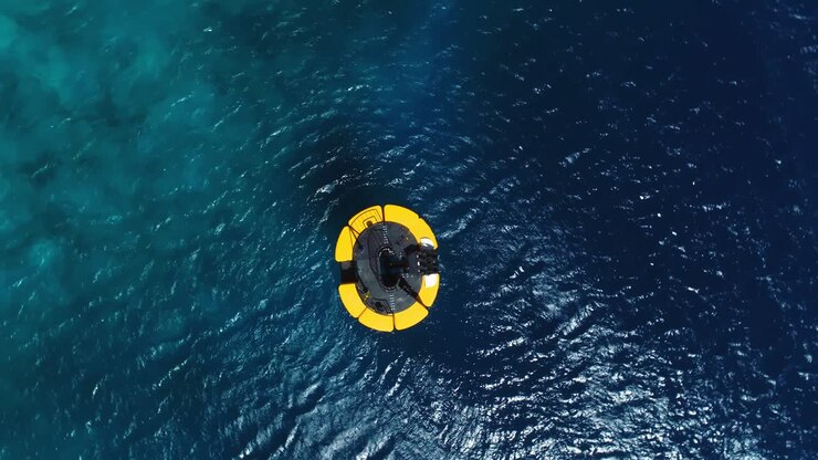 Drone top down shot on yellow mooring buoy in deep blue Caribbean ocean, small waves and wind ripples