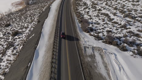 Toma-Aérea-Inclinada-De-Un-Automóvil-Conduciendo-A-Través-De-Las-Montañas-Rocosas