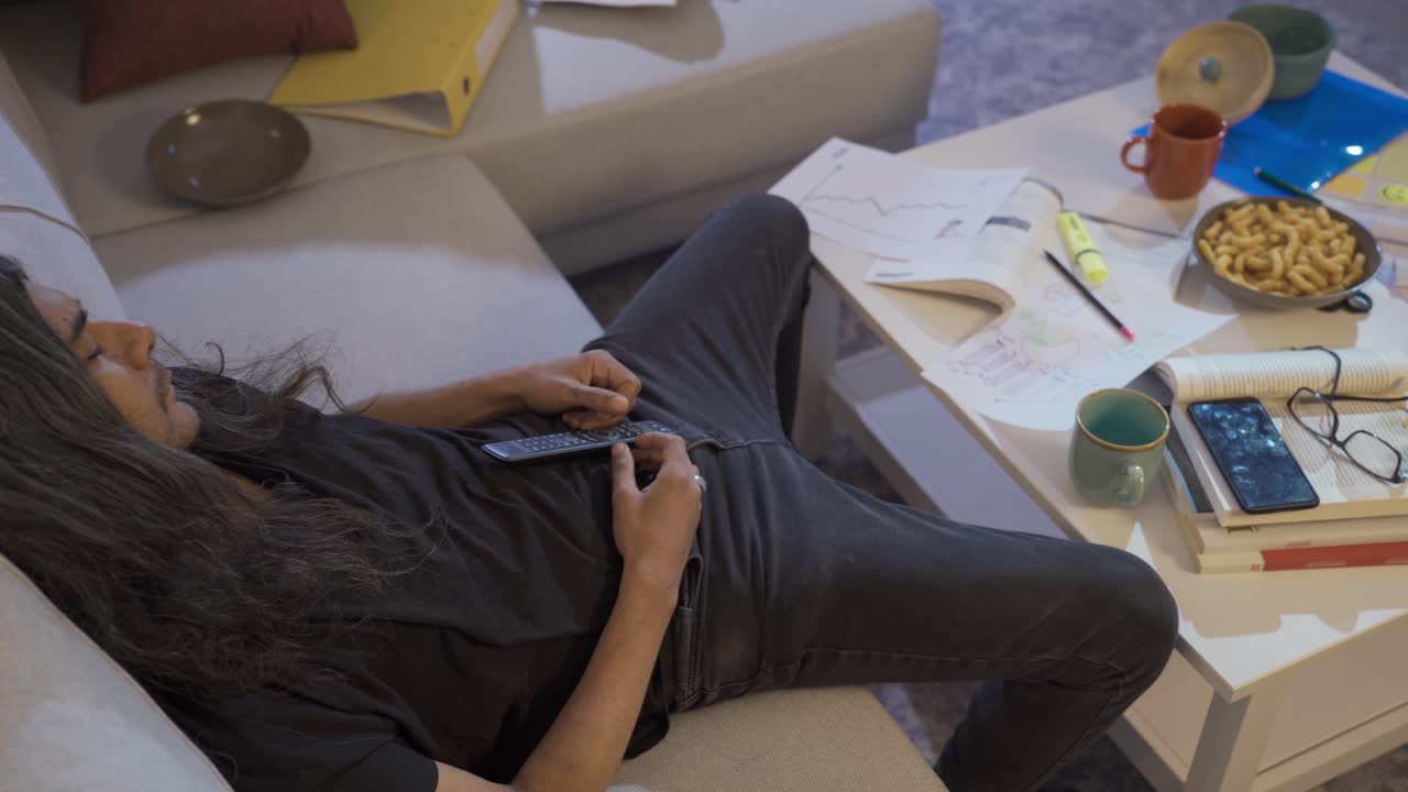 ⁇ 망진창하고 게으른 남자가 텔레비전을 보면서 잠들어 있습니다.