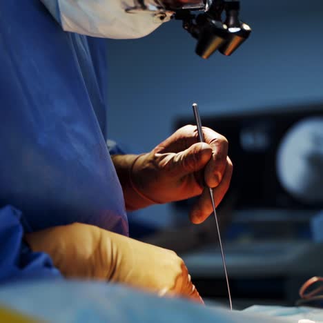 professional doctor in mask conducts a surgery. surgeon in surgical lights on head performing an operation to a patient with medical instrument