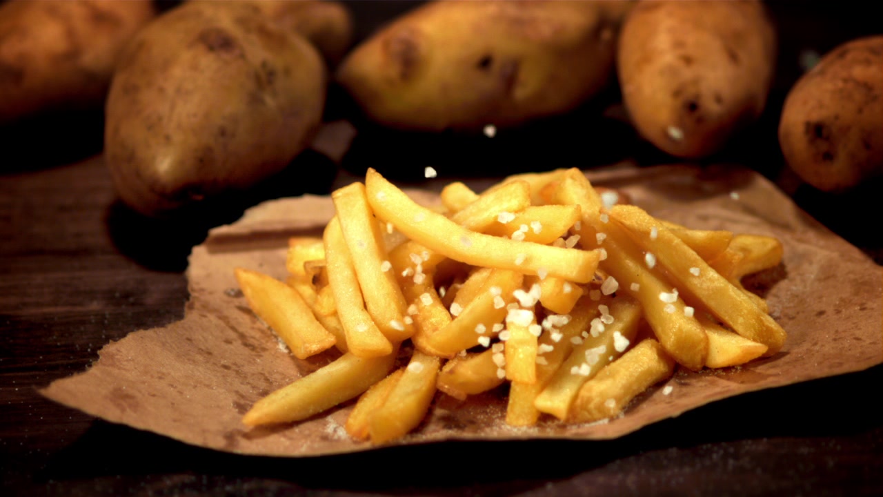 Salatura di patatine fritte dorate in movimento rallentato