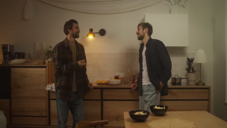 dos hombres relajándose en la cocina durante los bocadillos