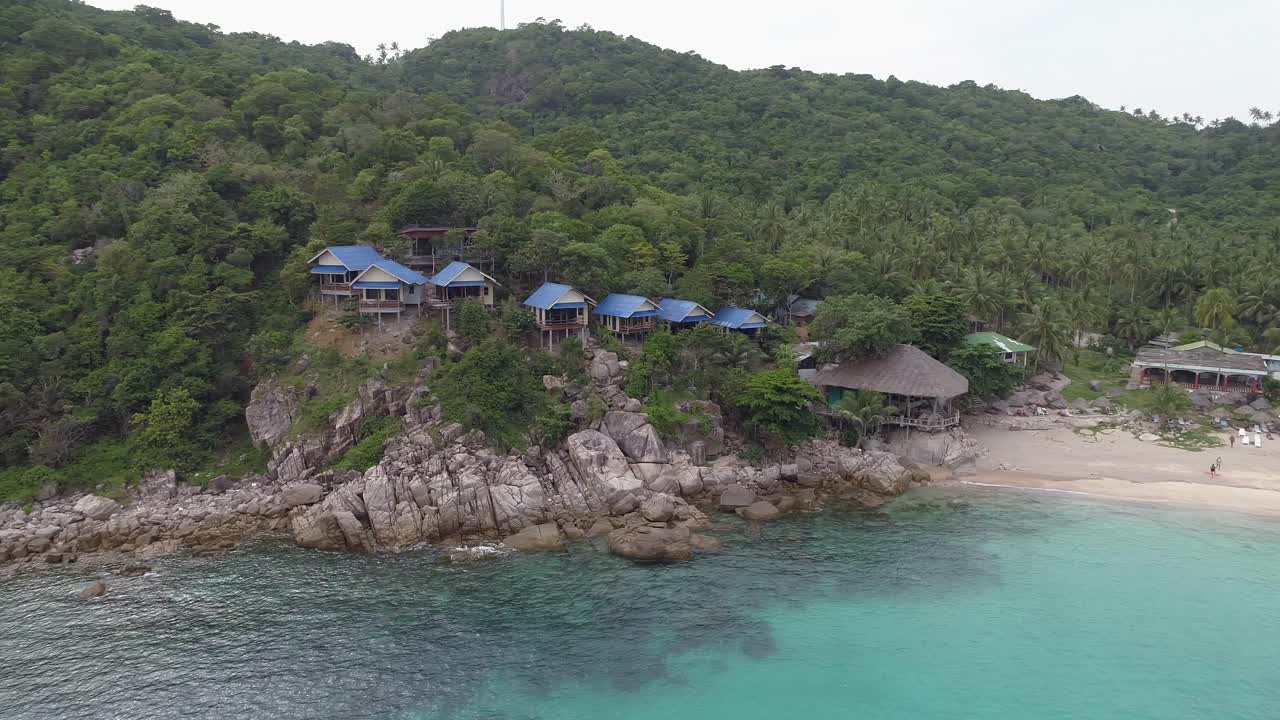 Aerial View of a Tropical Beach Resort with Palm Trees and Crystal Clear Water