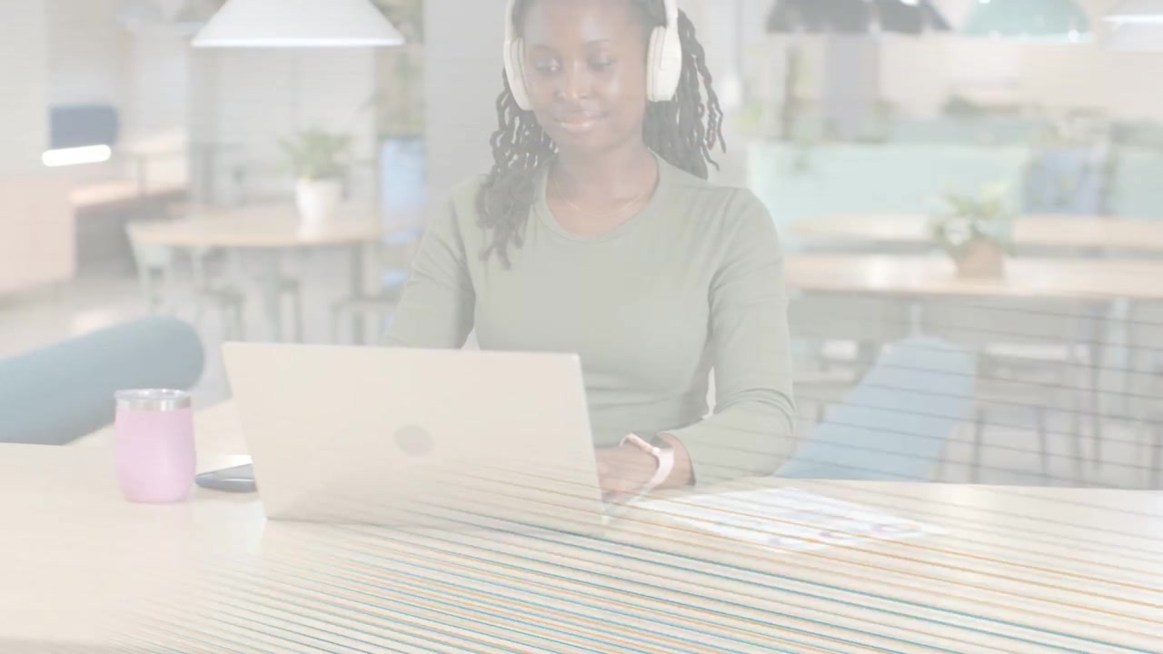Mulher digitando no laptop em um espaço de coworking, com linhas de varredura esporádicas sobrepondo a imagem, afetando o trabalho de tecnologia.