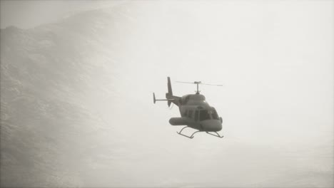 helicóptero volando en cámara lenta extrema cerca de las montañas con niebla