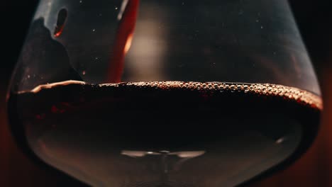 orange or red wine bottle and glass against a sunset in a peaceful vineyard, pouring of ecological natural wine.
