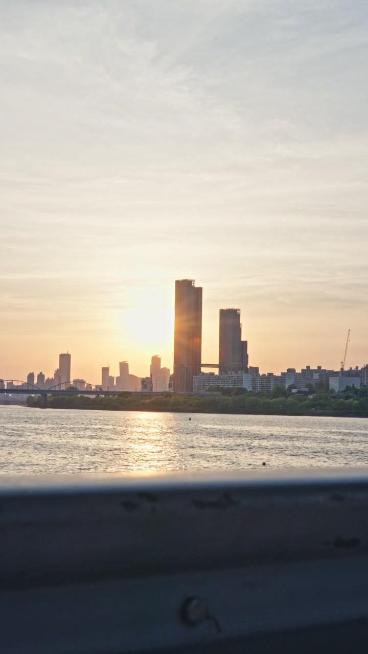 O Parque Hangang, ao longo do Rio Han, oferece vistas vibrantes da orla, horizontes urbanos e a Ponte Banpo, onde os moradores se reúnem para relaxar, passear e apreciar os pores do sol da hora dourada. Este é um pôr do sol de pico da primavera.