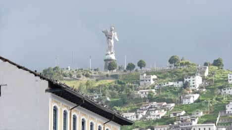 Vögel-Schweben-über-Traditionellen-Gebäuden-In-Quito,-Ecuador-–-Im-Hintergrund-Das-Epische-Statuendenkmal-„El-Panecillo“-„La-Virgen-Del-Panecillo“.