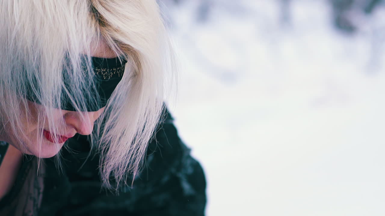 피닉스 복장을 입은  ⁇ 은 립스틱을 입은 여성이 눈에 떨어집니다.