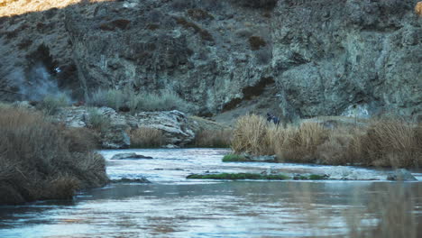 water stream and hot spring steam, mountain background, hot creek geological site, rack focus, dolly