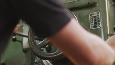 caucasian male hands factory worker at a factory standing at a workbench and operating machinery