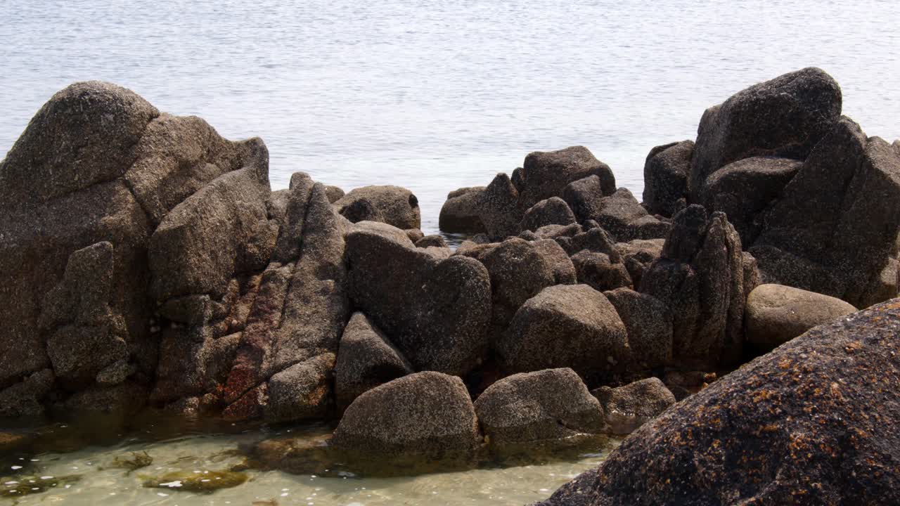 una serie de rocas erosionadas y el mar bañando alrededor entonces en la playa de st agnes en las islas de scilly 3 de 6