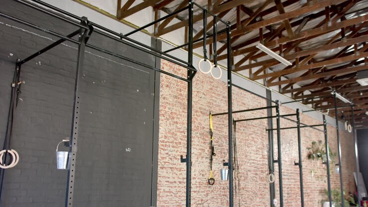 Gym equipment hanging from ceiling in a room with brick walls