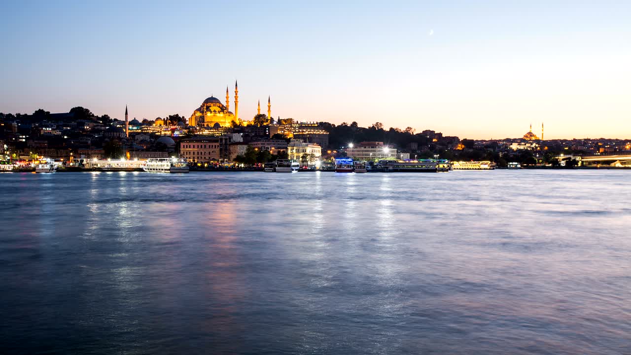 vista en lapso de tiempo del paisaje urbano de estambul con la mezquita de suleymaniye con barcos turísticos flotando en el bósforo por la noche