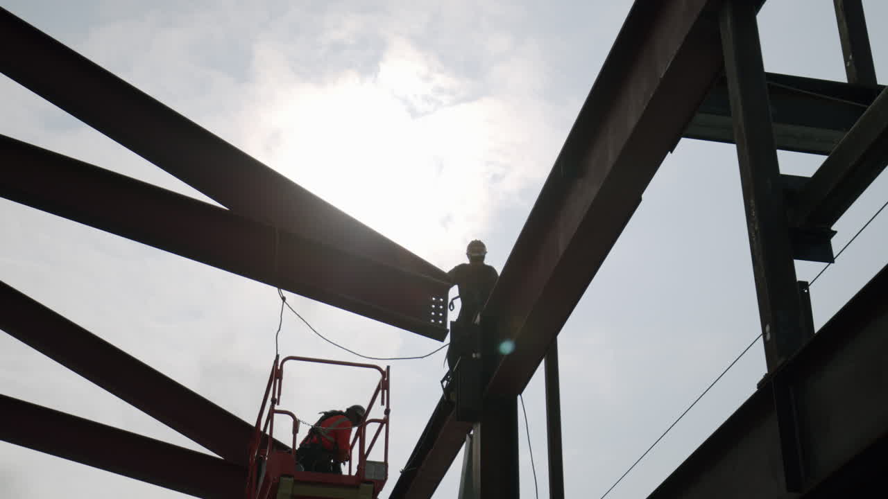 Construction workers on steel beams at a building site