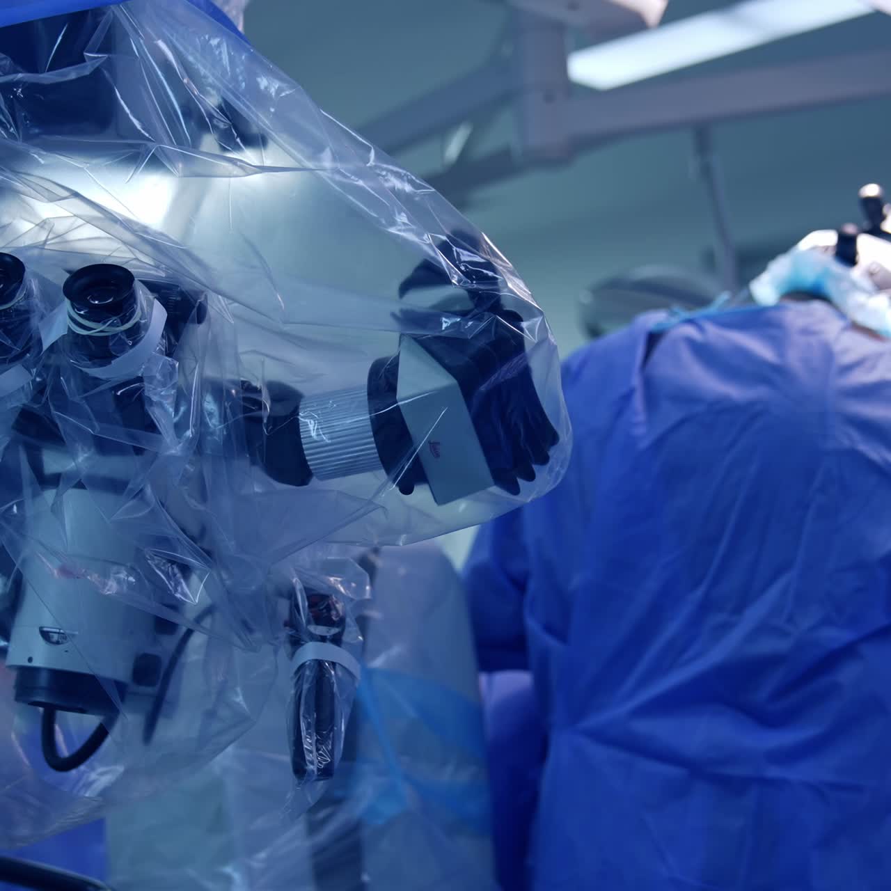 Technological advanced microscope in plastic at surgery room. Two surgeons operating the patient at backdrop