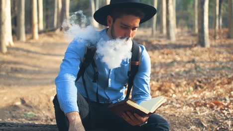 explorador vapeando y leyendo en el bosque