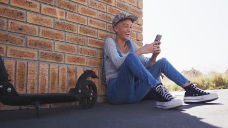mixed race woman using smartphone on the street