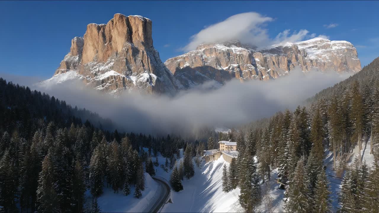 Stunning Aerial View of Majestic Mountain Peaks Surrounded by Lush Evergreen Forests and Enveloping Clouds in a Serene Winter Landscape