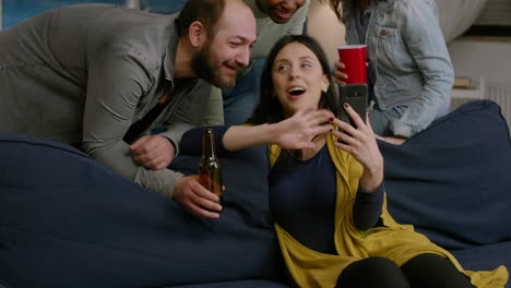 Multi-ethnic-friends-hanging-out-together-sitting-on-sofa-in-living-room