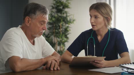 caucasian senior talking with female doctor at home.