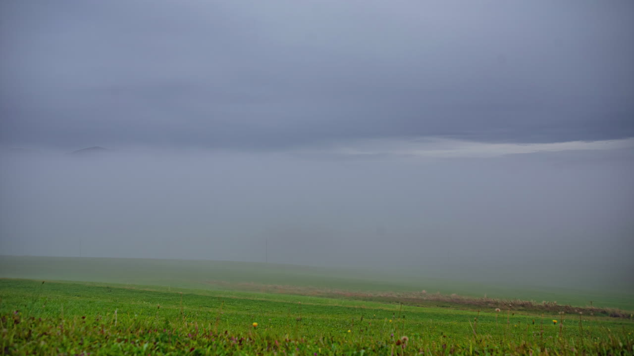 낮은 안개가 산 아래의 시골 계곡을 가득 채우고 있습니다.