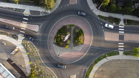 rising shot of traffic circle in bend, oregon with cars circling