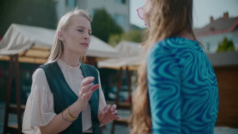 two women talking outdoors