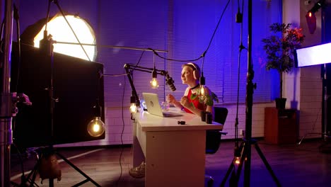 woman recording a podcast or live stream in a studio setting
