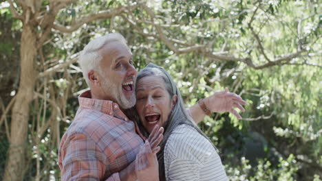 Portrait-of-smiling-middle-aged-caucasian-couple-in-garden-with-copy-space