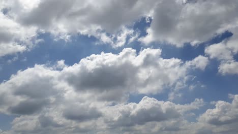 Blauer-Sommerhimmel-Mit-Dichten,-Dicken-Regenwolken,-Die-Sich-über-Den-Himmel-Bewegen