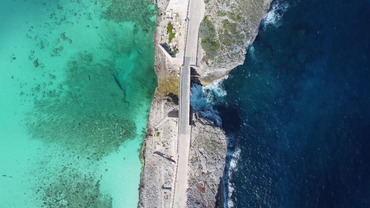 Cinematic aerial view still top down drone shot of an empty glass window bridge on the island of eleuthera in the bahamas - separating the atlantic ocean from the caribbean sea