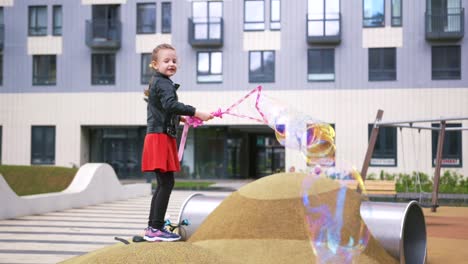 little girl playing with bubbles in a park