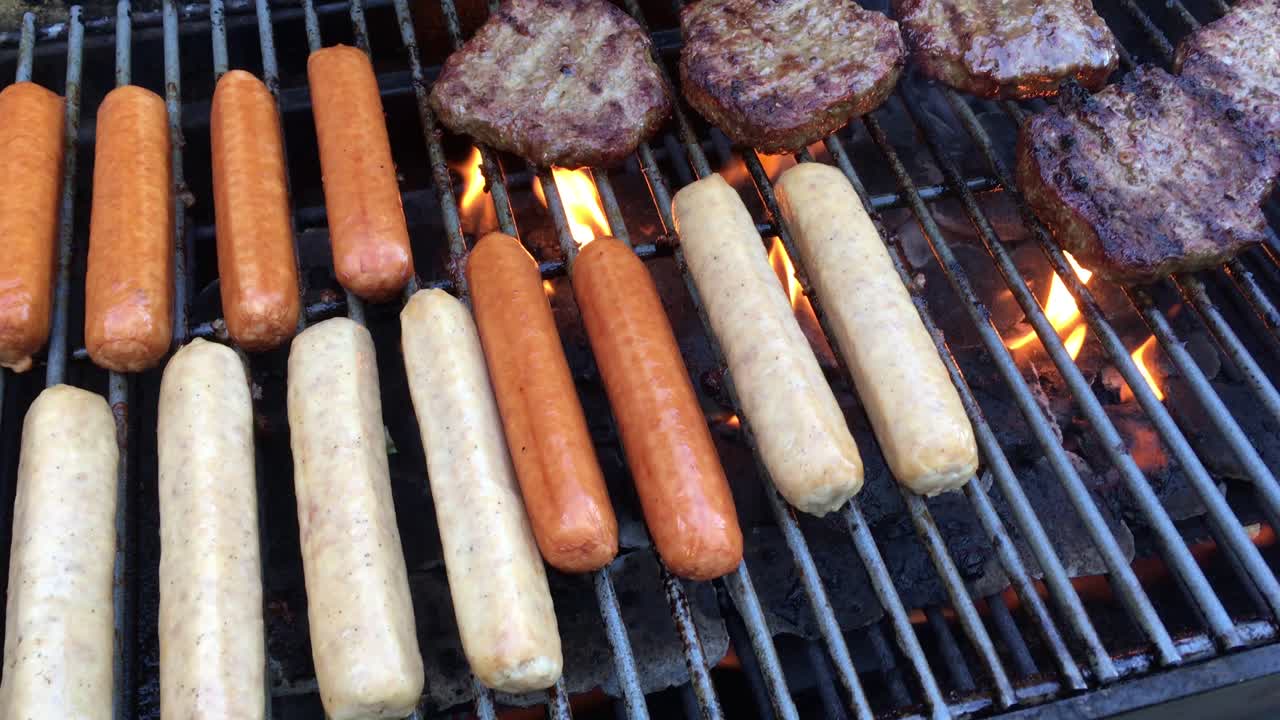 cocinar hamburguesas y mocosos en una parrilla de propano al aire libre