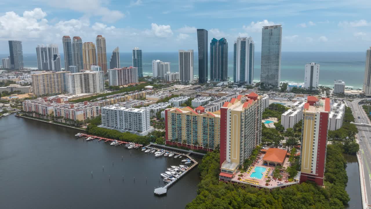 impresionante hiperlapso aéreo de la playa de las islas soleadas, mostrando edificios modernos de gran altura, costa y puerto deportivo