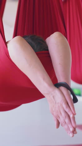 different tired people relax after workout and lie with joined palms above head in fly yoga hammocks close view