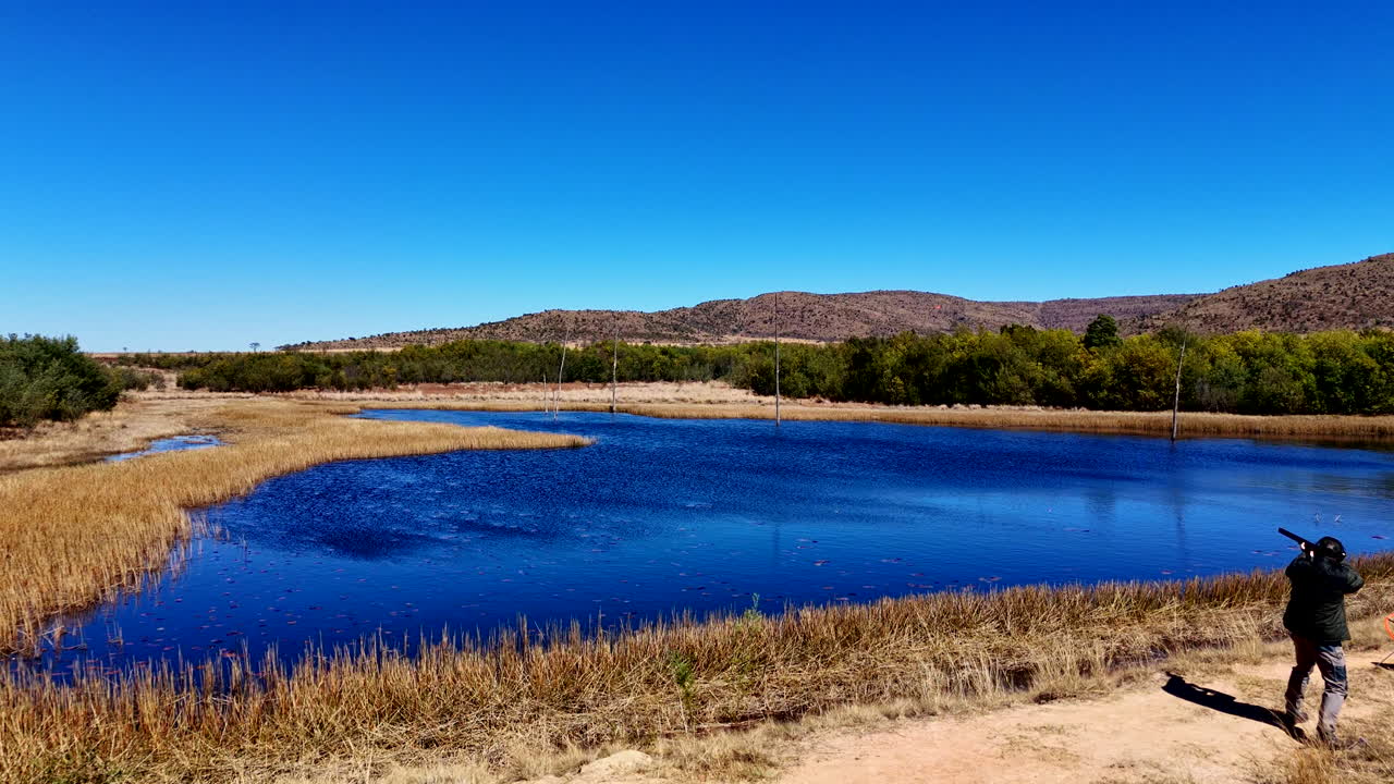 Leisure activity clay pigeon shooting on dam wall in South African countryside