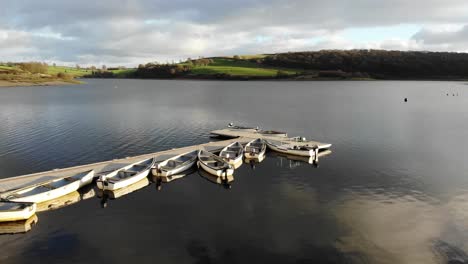 aerial flying over pier with empty boats moored at wimbleball lake on exmoor in somerset