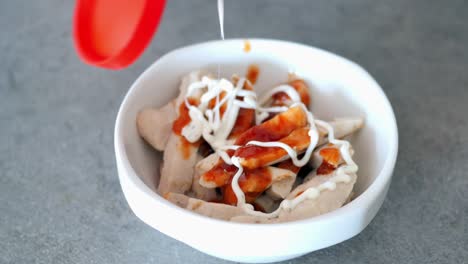 verter salsa en la pechuga de pollo a la parrilla en rodajas