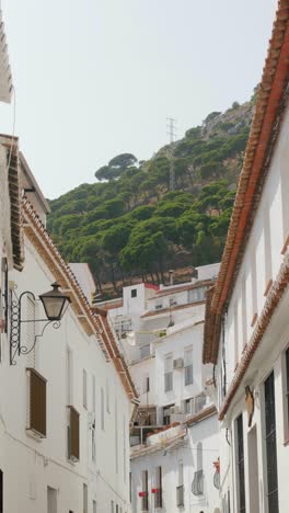 slow motion pov shot walking between whitewashed andalusian houses in mijas pueblo with hillside view