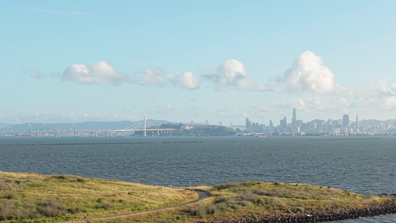 An aerial panning view of the Berkeley shore with Bay Bridge and the San Francisco skyline in the distance. Filmed in 4K on a DJI Air 3S.