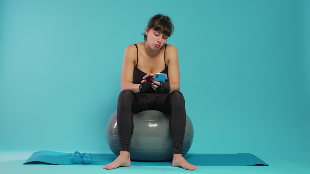 Active person yawning and using smartphone on break from workout