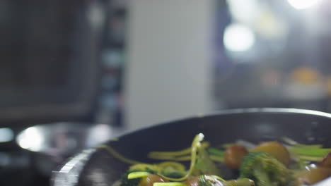 tossing veggies on skillet