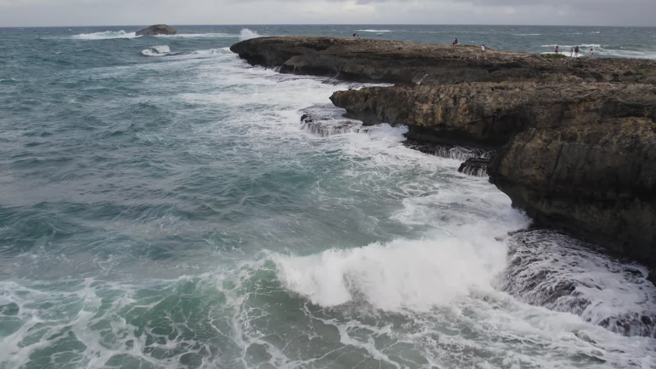 Onde che si infrangono contro una punta rocciosa a Laie, Oahu, Hawaii. Ripresa aerea con drone.