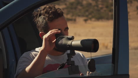 two people dialing in their target with a spotting scope