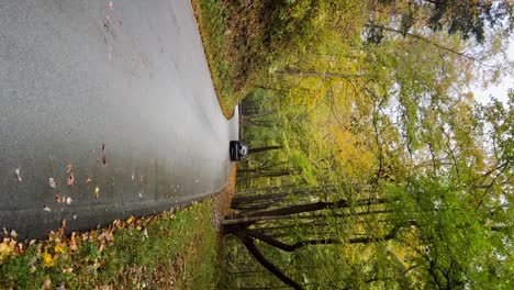 car driving through frame walking down an old country road in frankfort, kentucky during fall - vertical